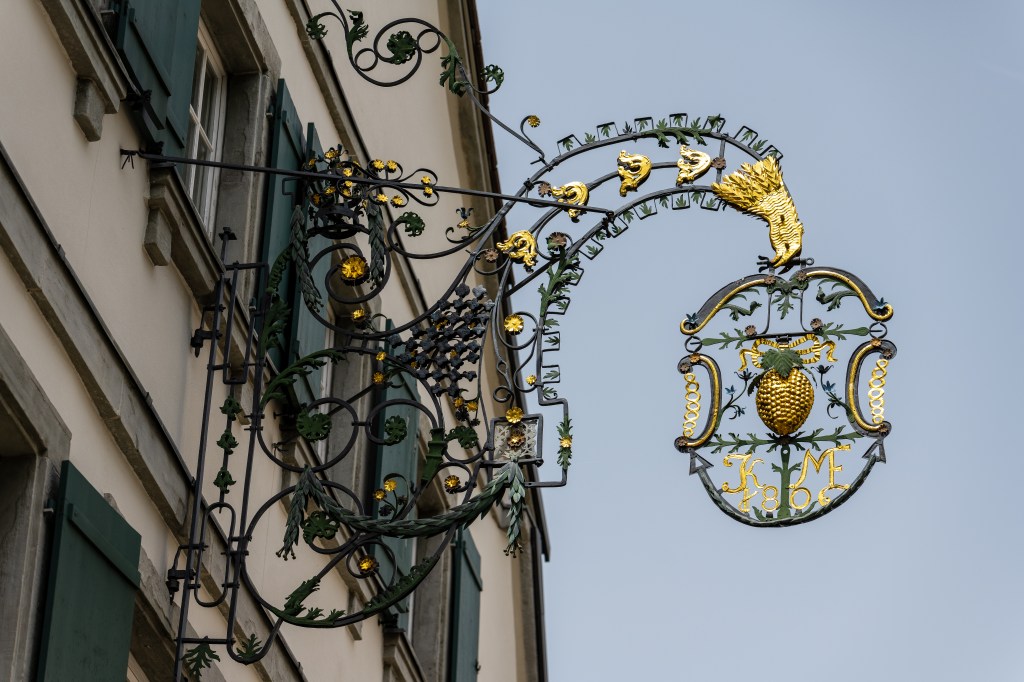 Der Haupteingang vom Gasthaus zur Traube mit historischer, goldener Traube über dem Eingang
